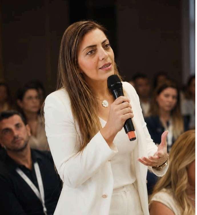Sofia Antunes a falar em palco, de microfone na mão